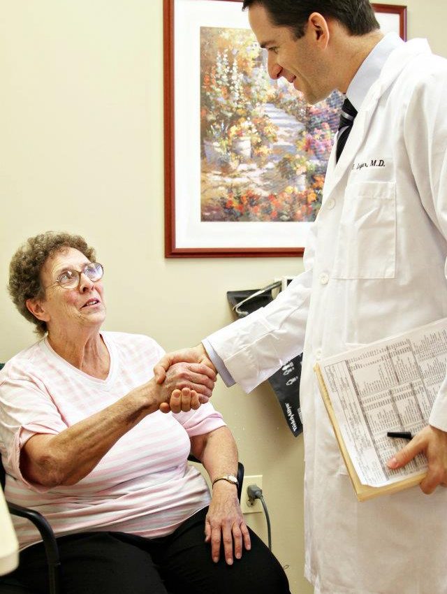 Happy patient hand shaking with doctor